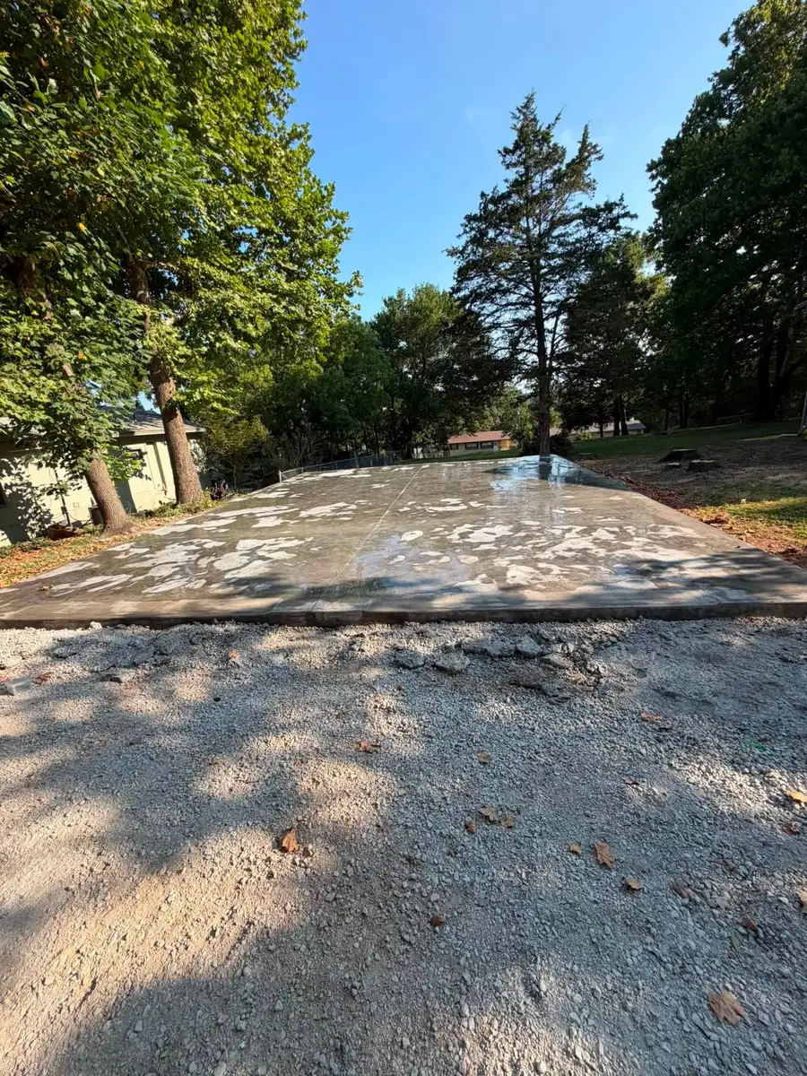 Concrete Pads A finished concrete slab poured on a prepared base, with a gravel apron along its front edge