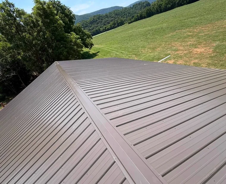 Metal Roof Installation A finished metal roof photographed along the ridge, panel ribs running to the eave