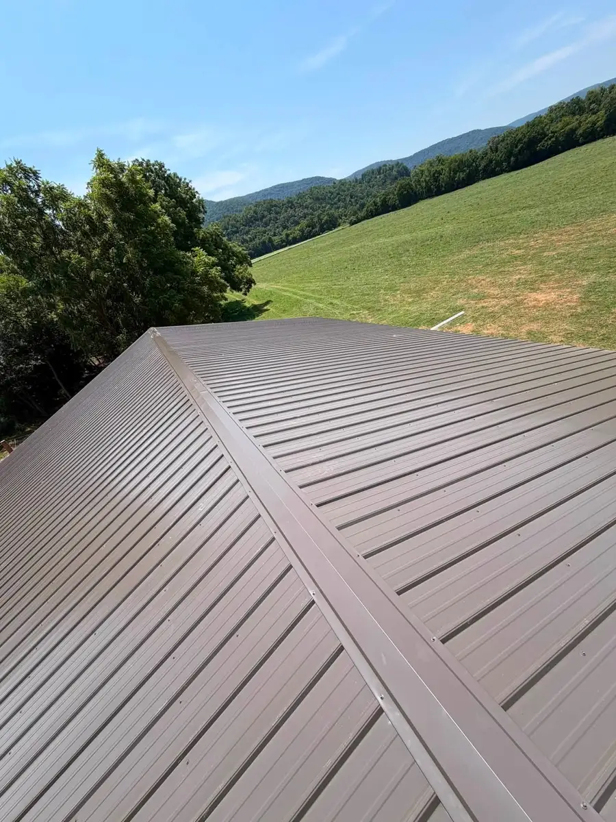 Metal Roof Installation A finished metal roof photographed along the ridge, panel ribs running to the eave