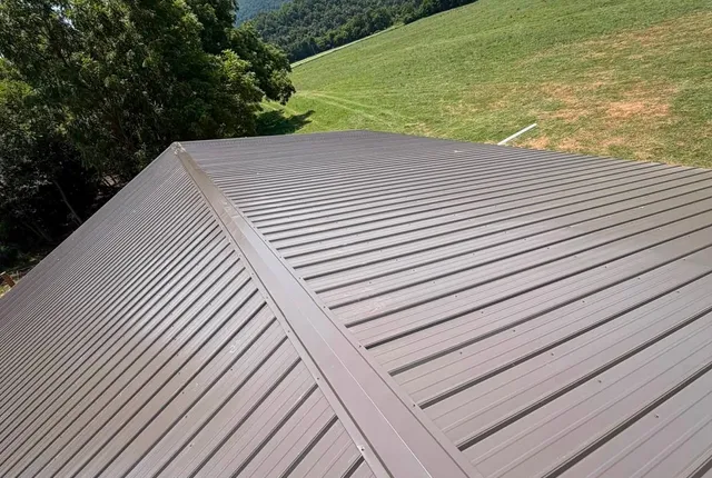 Finished metal roof, Jasper AR The finished brown metal roof photographed along the ridge, with a grass hillside and mountains beyond