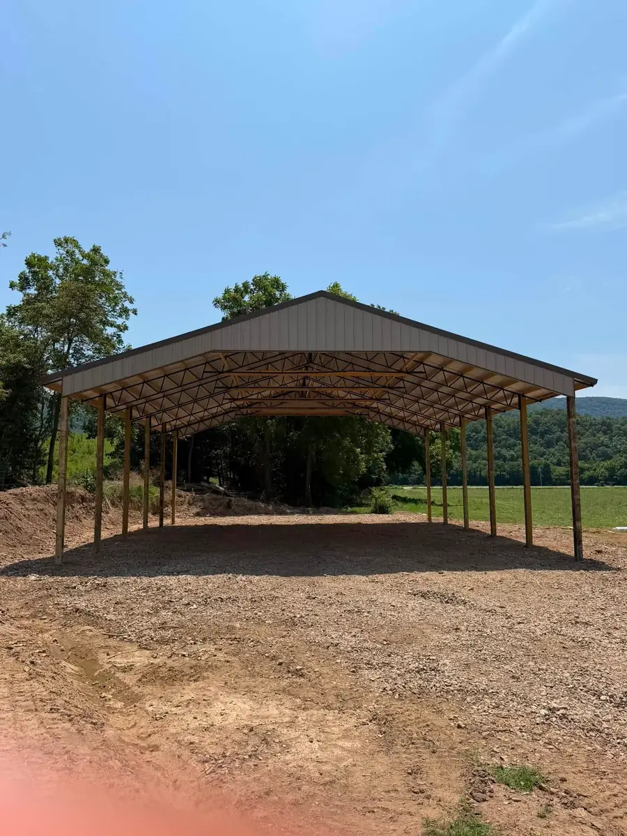 Car Ports An open-sided covered structure on timber posts with a metal gable roof, standing on gravel