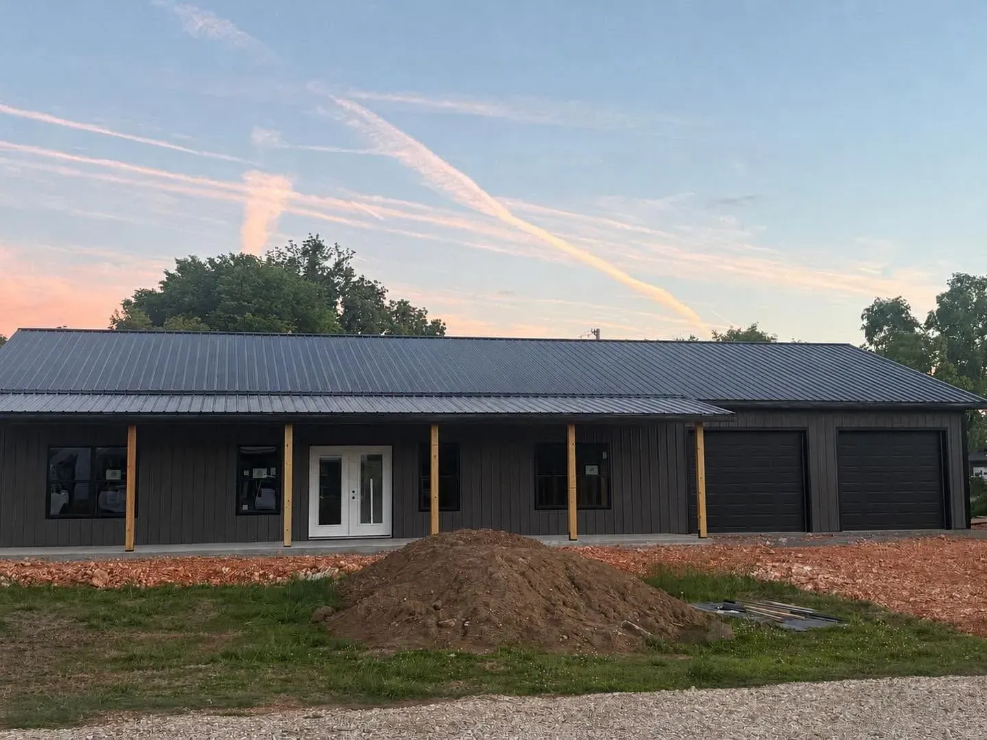 Sundown Roofing & Construction A finished metal roof and shop at sunset