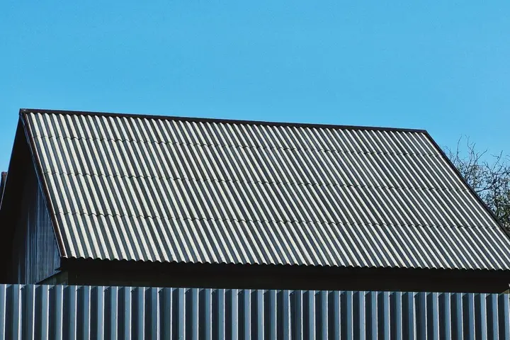 Side-by-side comparison of a metal roof and an asphalt shingle roof on homes in North Arkansas