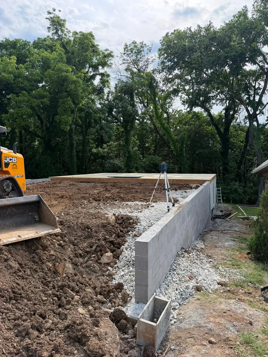 Foundations A concrete block stem wall with drainage stone along its base, set out with a laser level on a sloping site