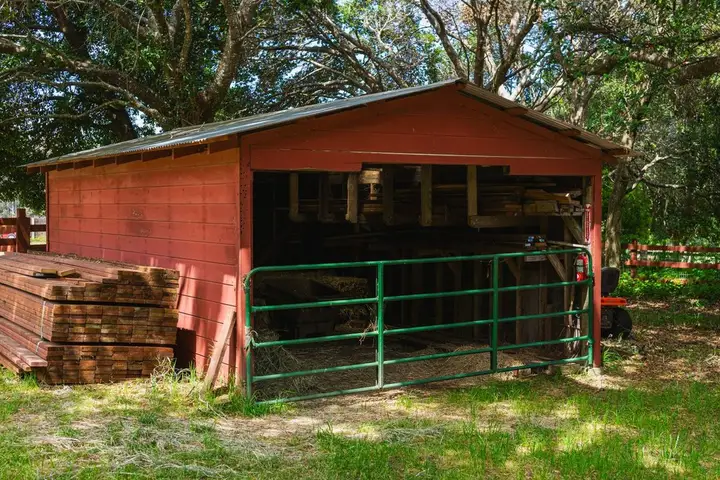 Post-frame pole barn with metal roof and siding under construction on a North Arkansas property